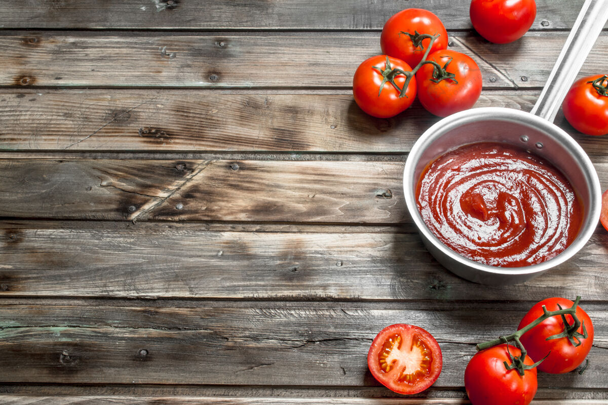 生的番茄沙司放在平底锅里熟透西红柿.on木桌锅味道烹饪