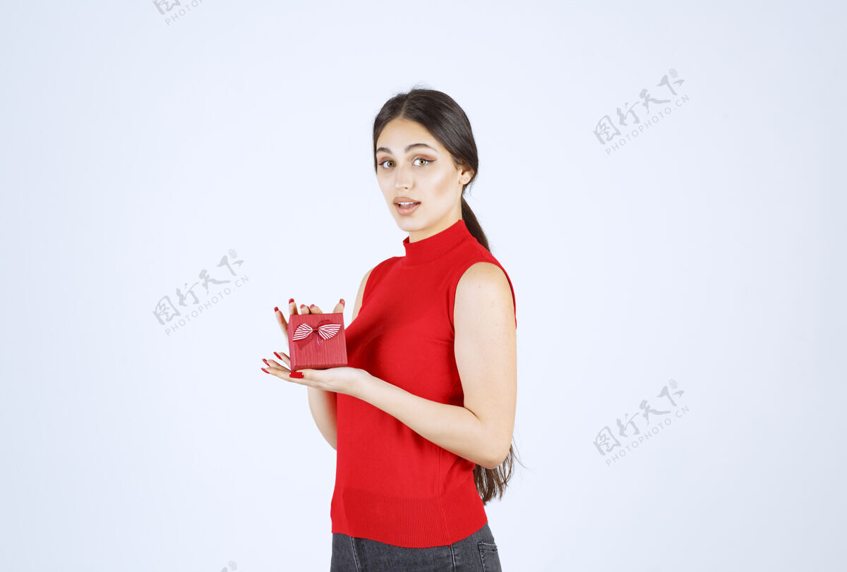 成人穿红衬衫的女孩展示她的红色礼盒职员年轻人休闲