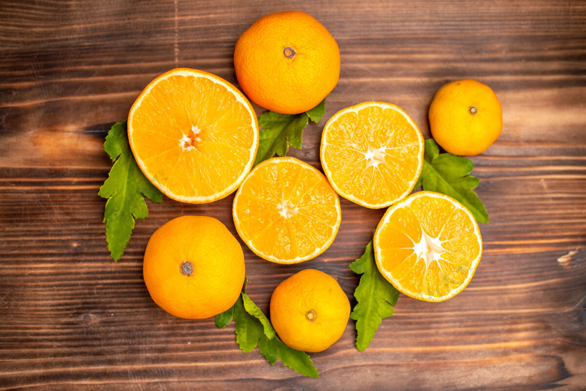 新鲜全切鲜橙子的特写镜头 叶子呈棕色背景健康鲜橙切