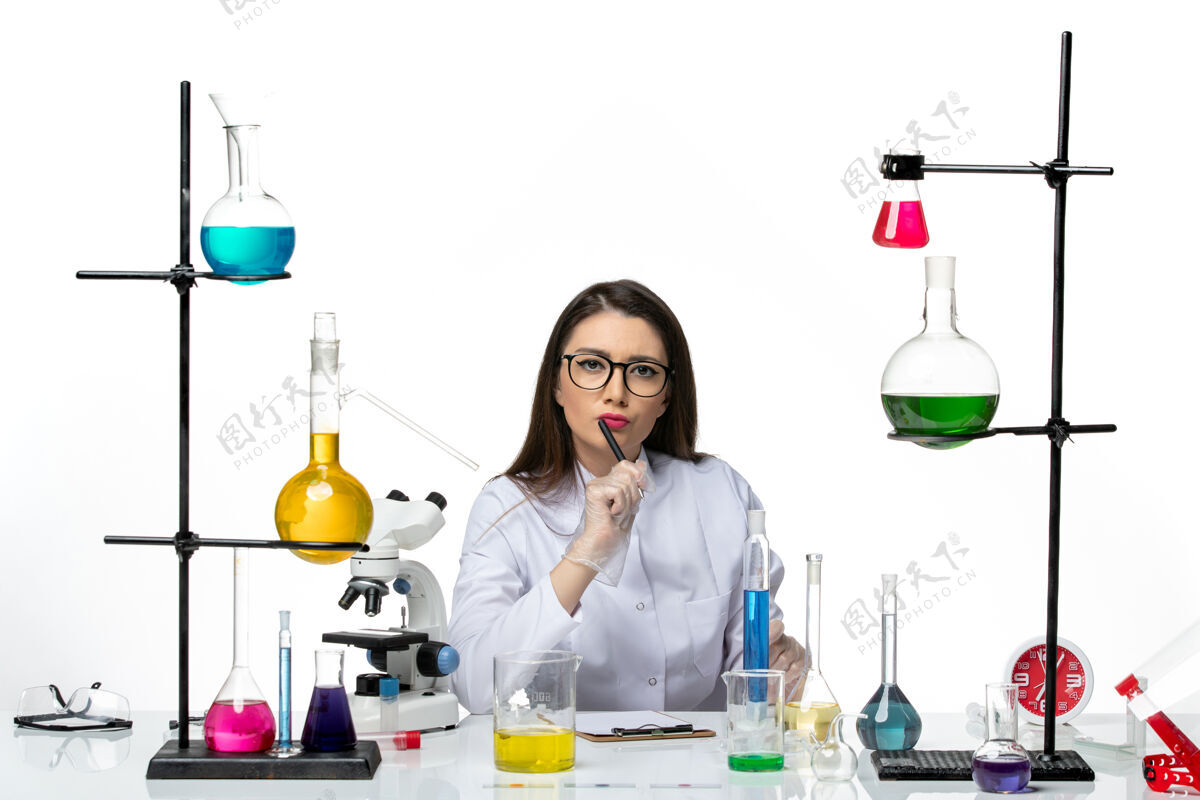 罐子前视图穿着白色医疗服的女化学家在一个白色背景的科学病毒冠状病毒-大流行实验室工作和写笔记视图套装瓶子
