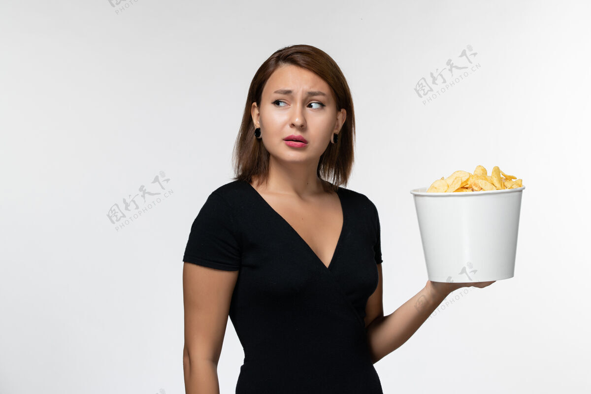 衬衫正面图：穿着黑色衬衫的年轻女性在白色的桌子上拿着薯片动画电影电影