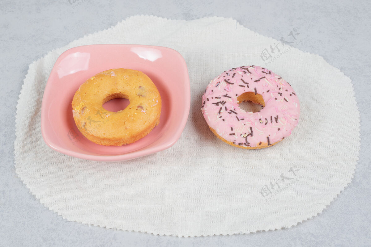 霜大理石桌上有两个带喷头的甜甜圈高质量照片甜甜圈碗面包房