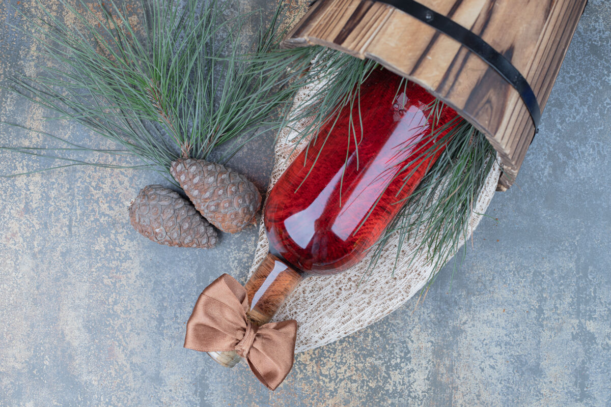 红两个松果与葡萄酒瓶大理石背景高品质的照片木头庆典桶