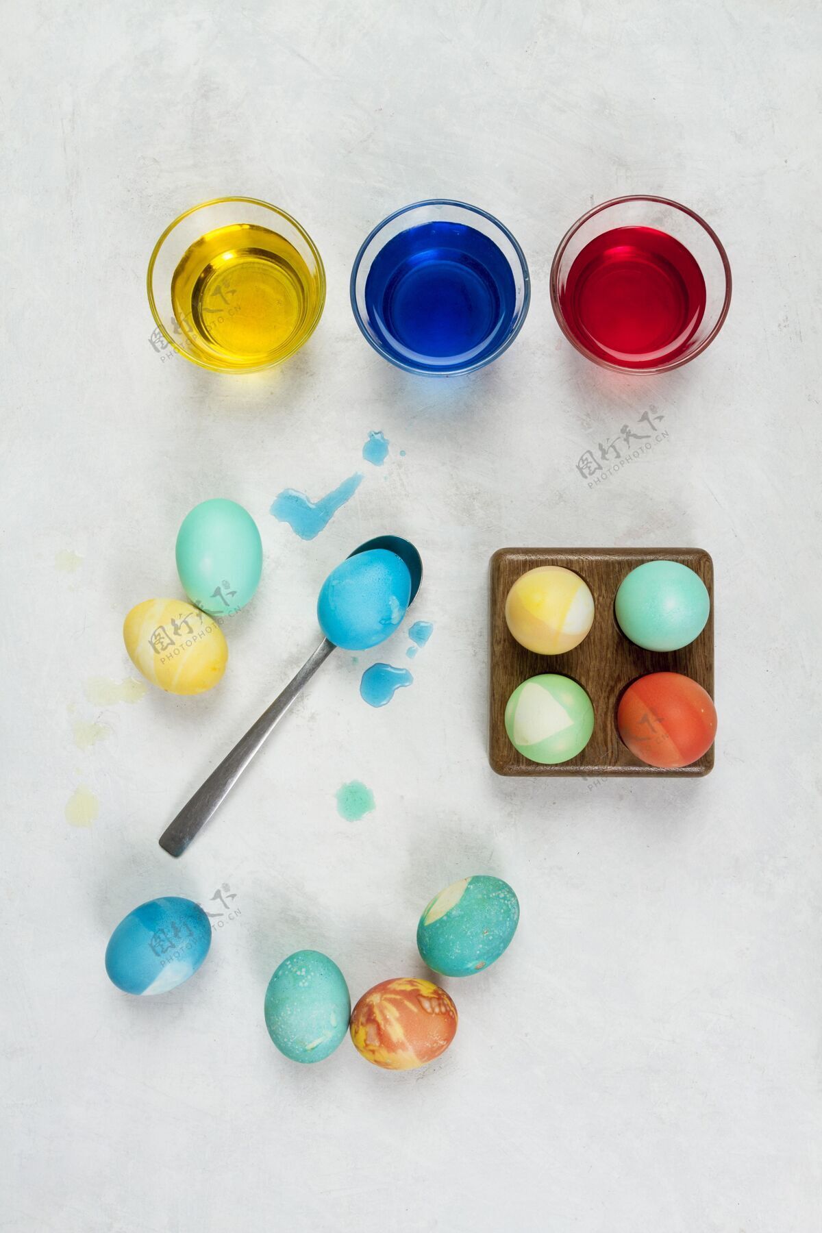 平铺复活节彩蛋的俯视图 用玻璃杯和勺子涂上颜料鸡蛋奉献复活星期天