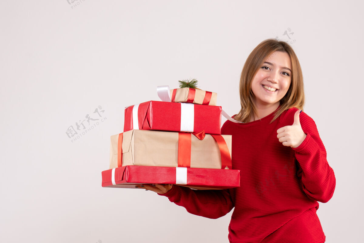 女人正面图年轻女性手拿礼物站着幸福礼物年轻的女人