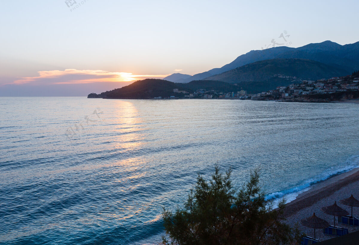 环境粉红色的日落和夏日海岸景观（希马尔 阿尔巴尼亚 波塔米海滩）城镇夜晚山