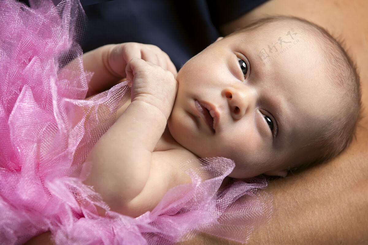 大美丽平静的新生女婴睁着眼睛宝贝 特写抱着欢呼孩子
