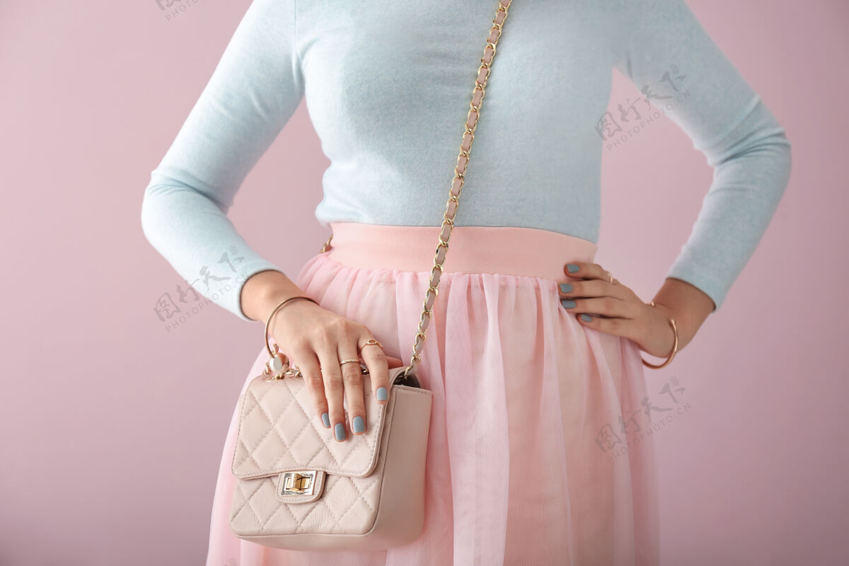 长袖漂亮的女人带着时髦的包和珠宝女性手模型