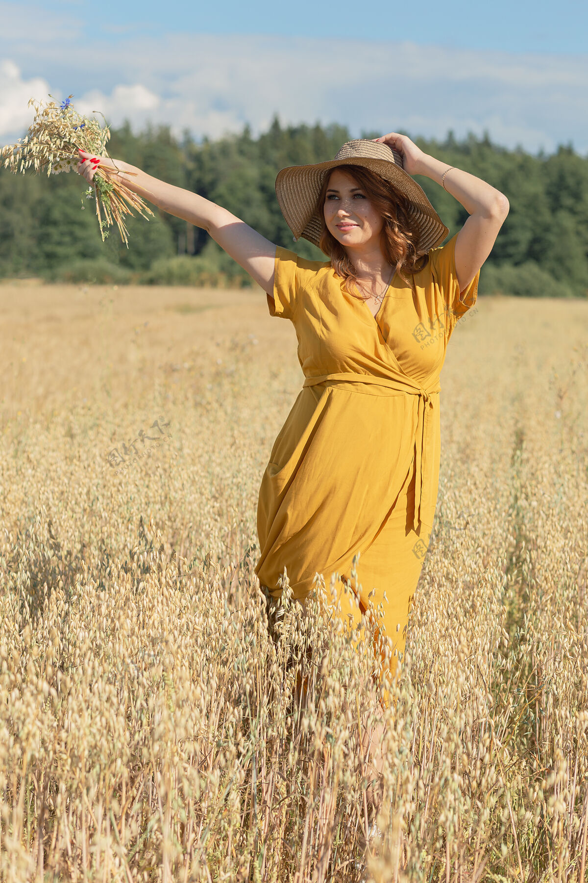 黄色在一个阳光明媚的夏日 一位年轻漂亮的孕妇穿着黄色的裙子 戴着黄色的帽子 走过一片麦田肚子自然农场