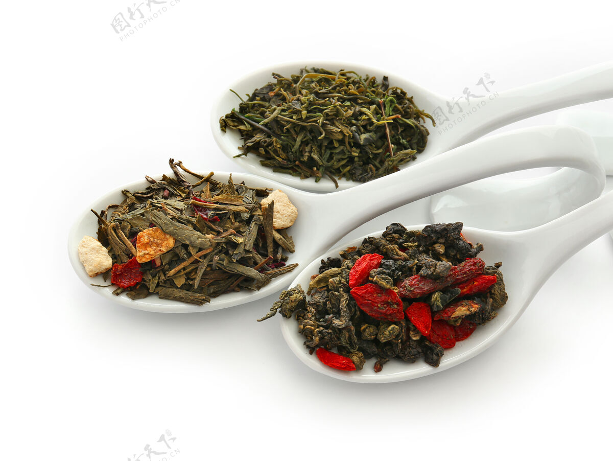 叶不同种类的干茶放在陶瓷汤匙里 隔离在白色上混合印度分类