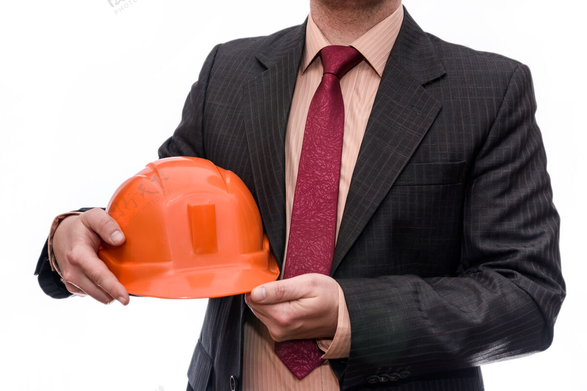 建造商穿西装的人拿着橙色头盔隔离在白墙上工业经理软