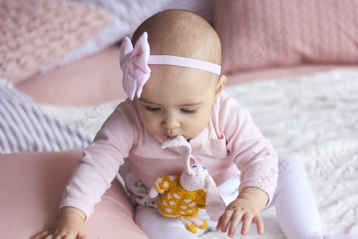 花束有趣的小女婴在粉红色明亮的现代内饰母亲节概念惊喜女儿微笑