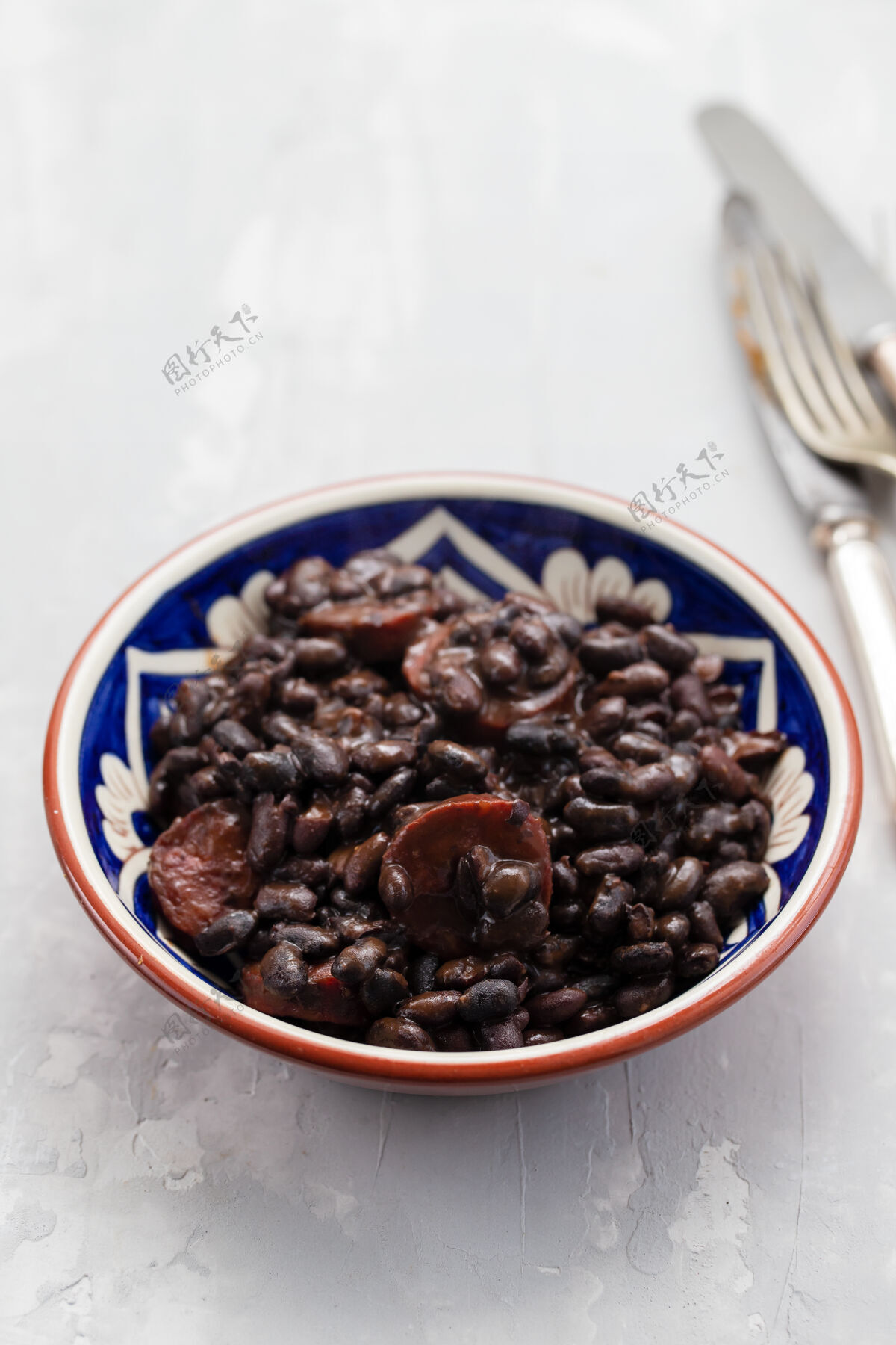菜肴黑豆和烟熏香肠放在陶瓷盘子里菜桌子民族
