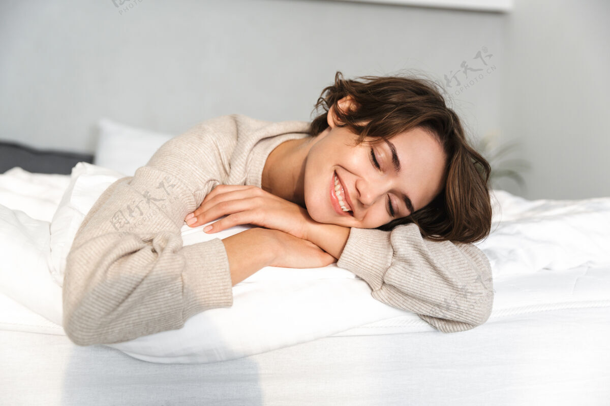 成人快乐的黑发女人在家躺在床上休息和享受闭着眼睛躺着黑发封闭