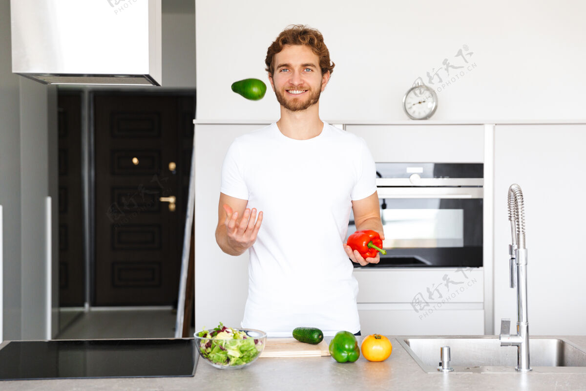 男人一个英俊的年轻人在厨房的照片在家做饭蔬菜做沙拉成人国内柔软
