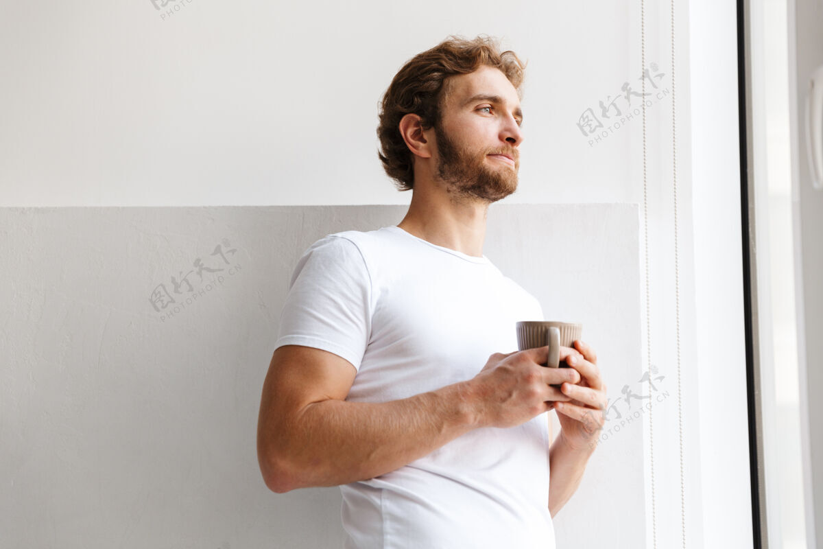 休闲一个英俊的年轻人在家喝咖啡的照片放松茶饮用