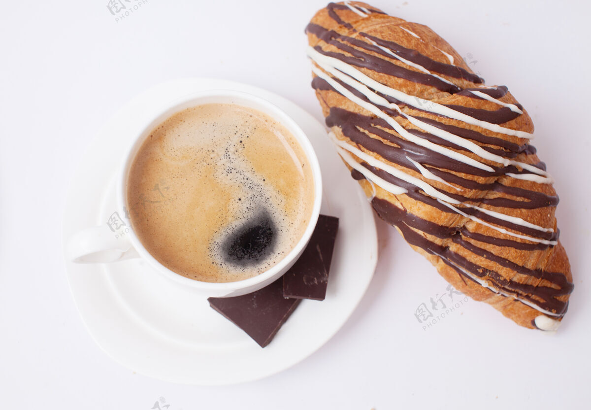 芳香早餐咖啡和羊角面包放在白色的桌子上咖啡因棕色背景