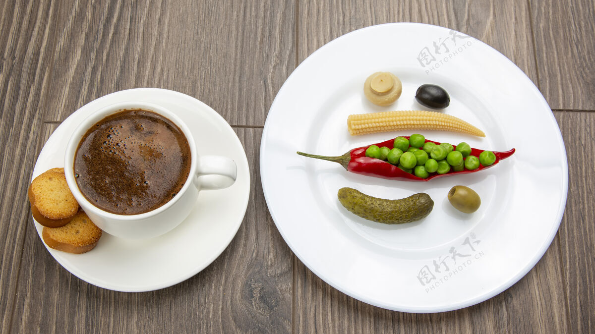 食用罐装蔬菜沙拉和一杯黑咖啡 盘子里有红辣椒和饼干产品新鲜黄瓜
