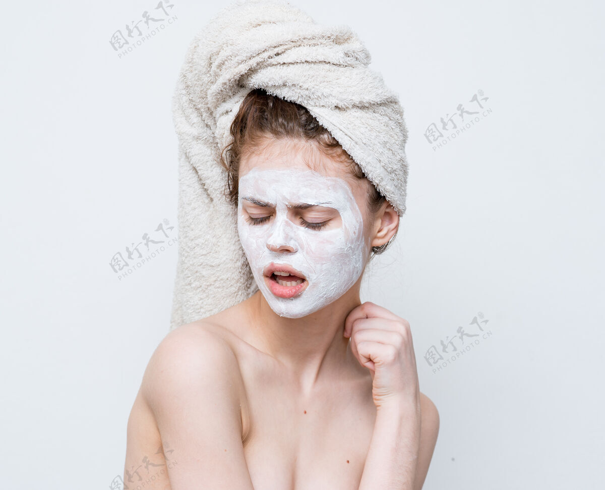 生活方式光着肩膀的女人头上戴着毛巾护肤面膜脸痤疮面部