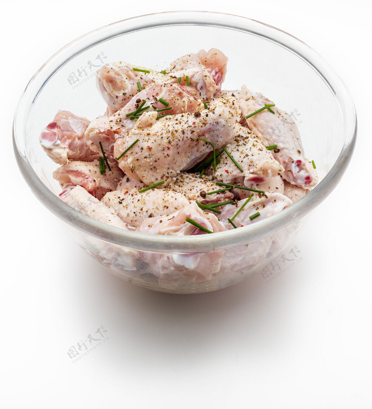 健康生鸡翅用盐 胡椒和韭菜腌制在一个碗里 在白色背景上分开骨头鸡干净
