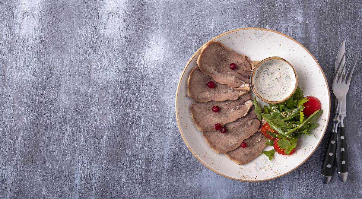 开胃菜用叉子和叉子盛在盘子里的牛舌片刀顶部查看 沙拉蔓越莓肉