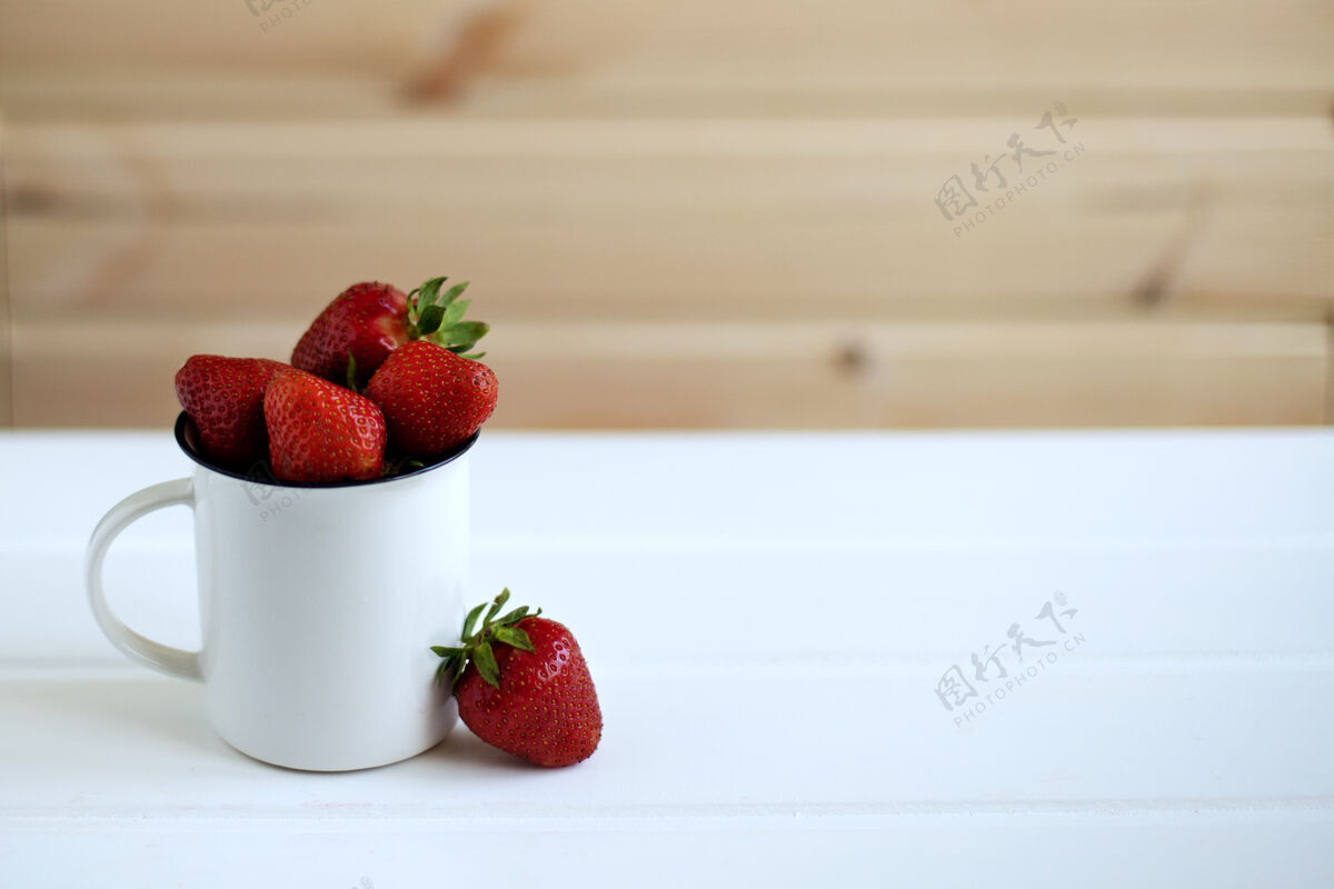 甜点一大杯草莓在白色木质背景上享受浆果有机