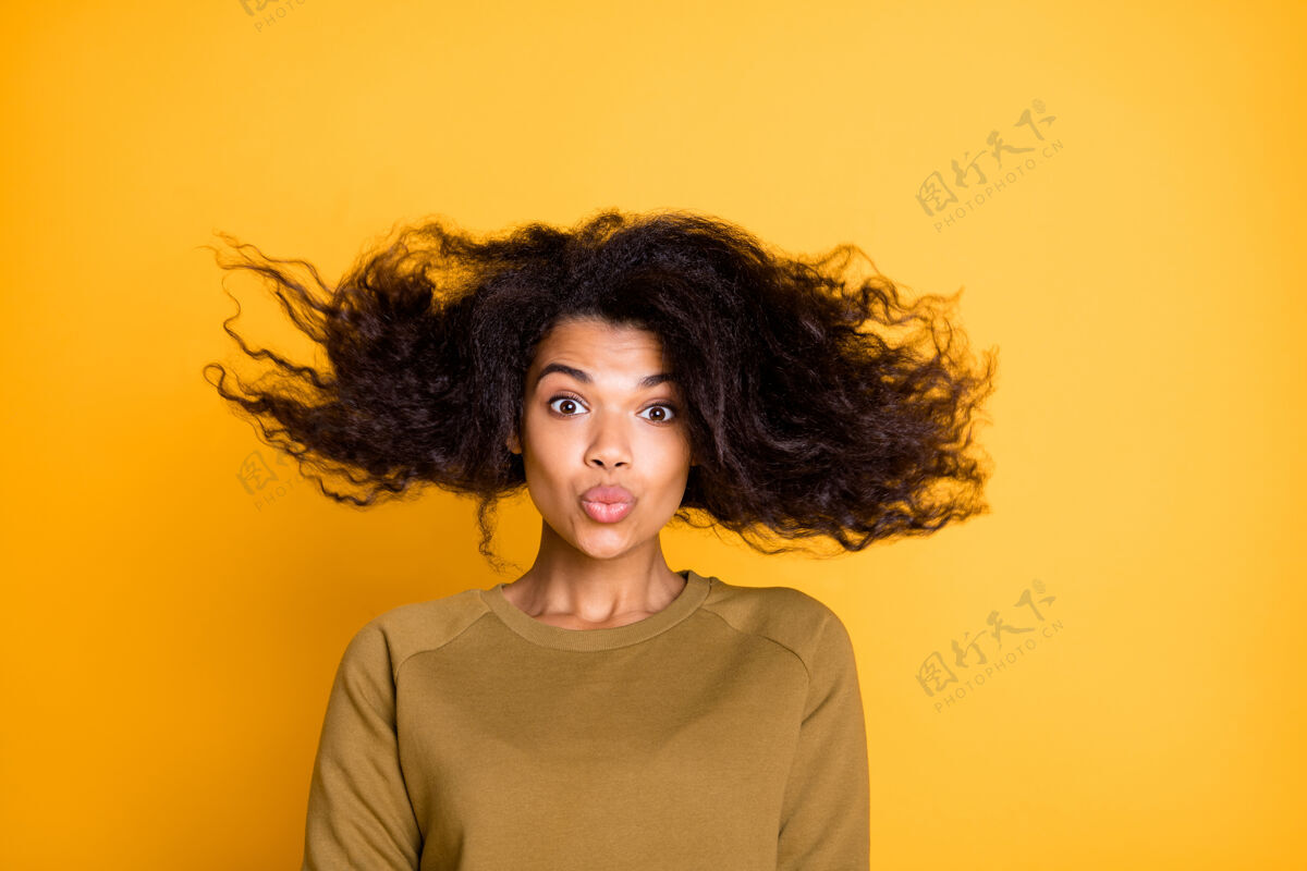 女性特写照片惊人的美丽黑皮肤女士温暖的秋风扔发型向上空气发送吻穿休闲套头衫隔离在黄色背景飞行表情美丽