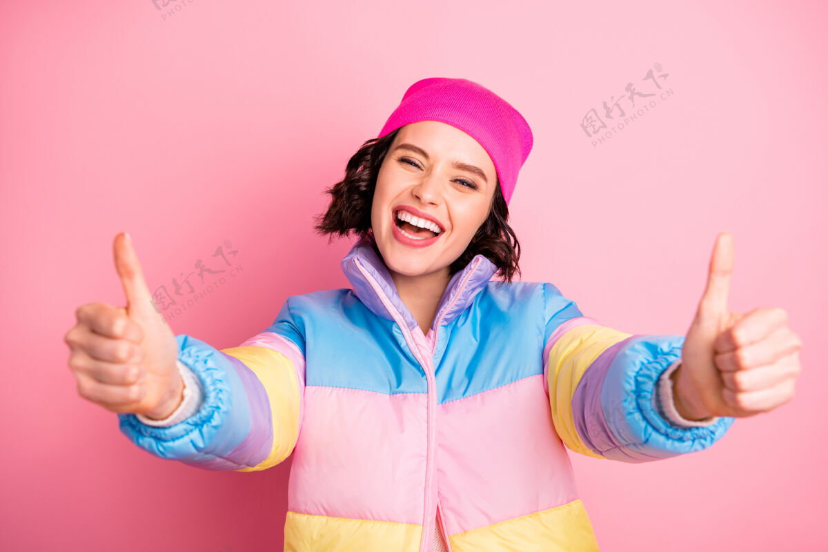 微笑好女人推荐酷新奇的照片竖起大拇指穿暖色外套隔离粉红色背景提示喜欢乐趣