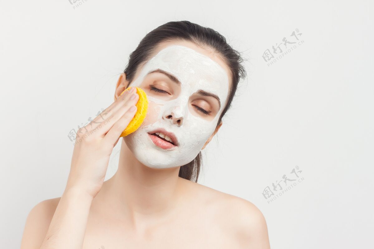 面霜光着肩膀 手上拿着屁股的女人把面具从脸上取下来面膜放松化妆棉