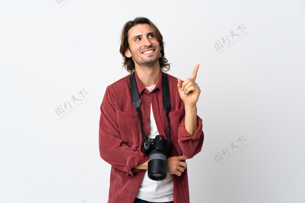 人一个年轻的摄影师站在白色的墙上 指着一个伟大的想法点设备人