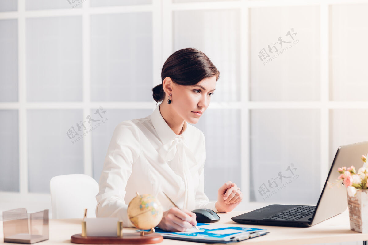 一人漂亮的女商人在办公室办公桌旁工作女性企业家自信