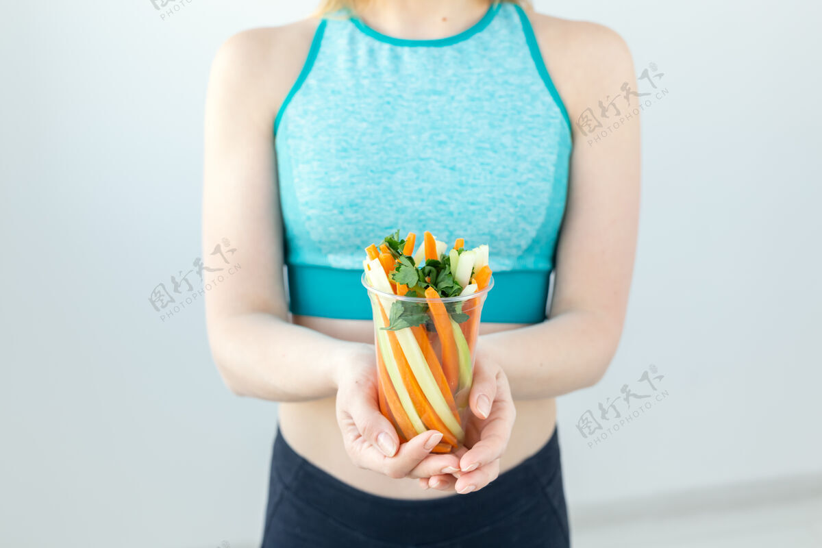吃健康生活方式的特写镜头女人拿着蔬菜在室内零食看景点
