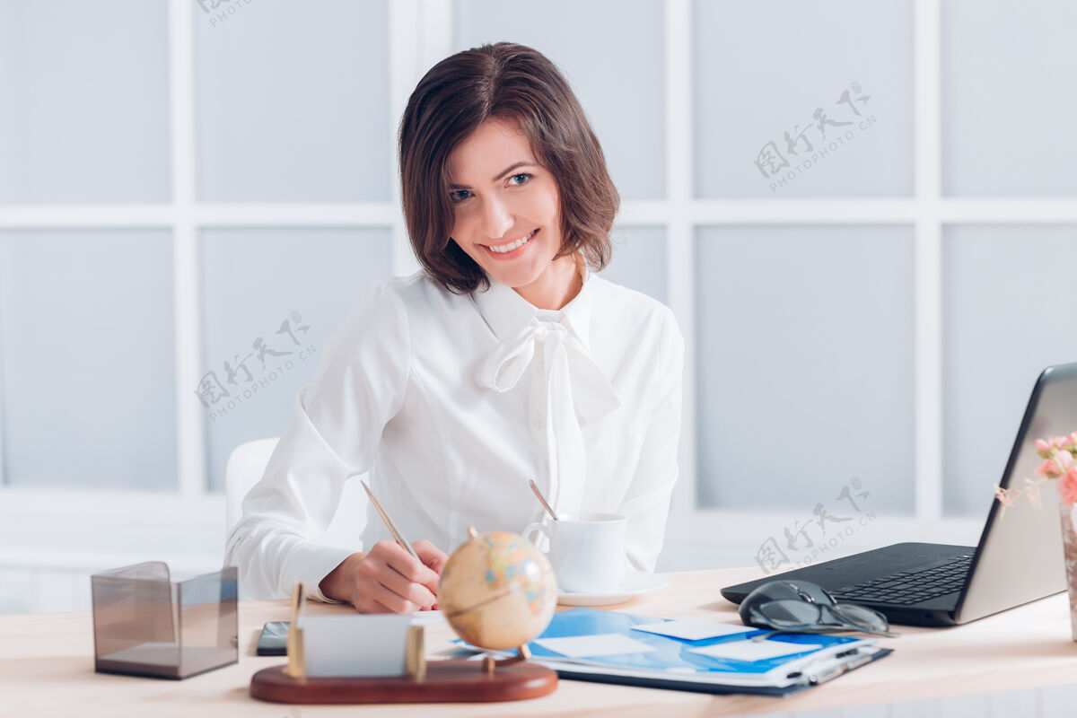 笔记本电脑漂亮的女商人在办公室办公桌旁工作人员互联网自信