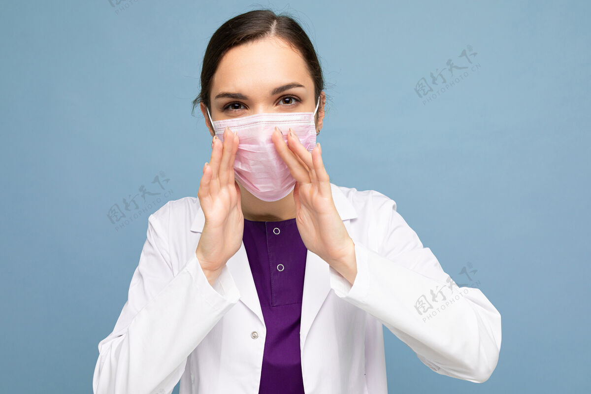 保护一位身穿白大褂 戴着医用口罩 孤零零地站在地上的迷人年轻女医生的画像信息讲话大流行