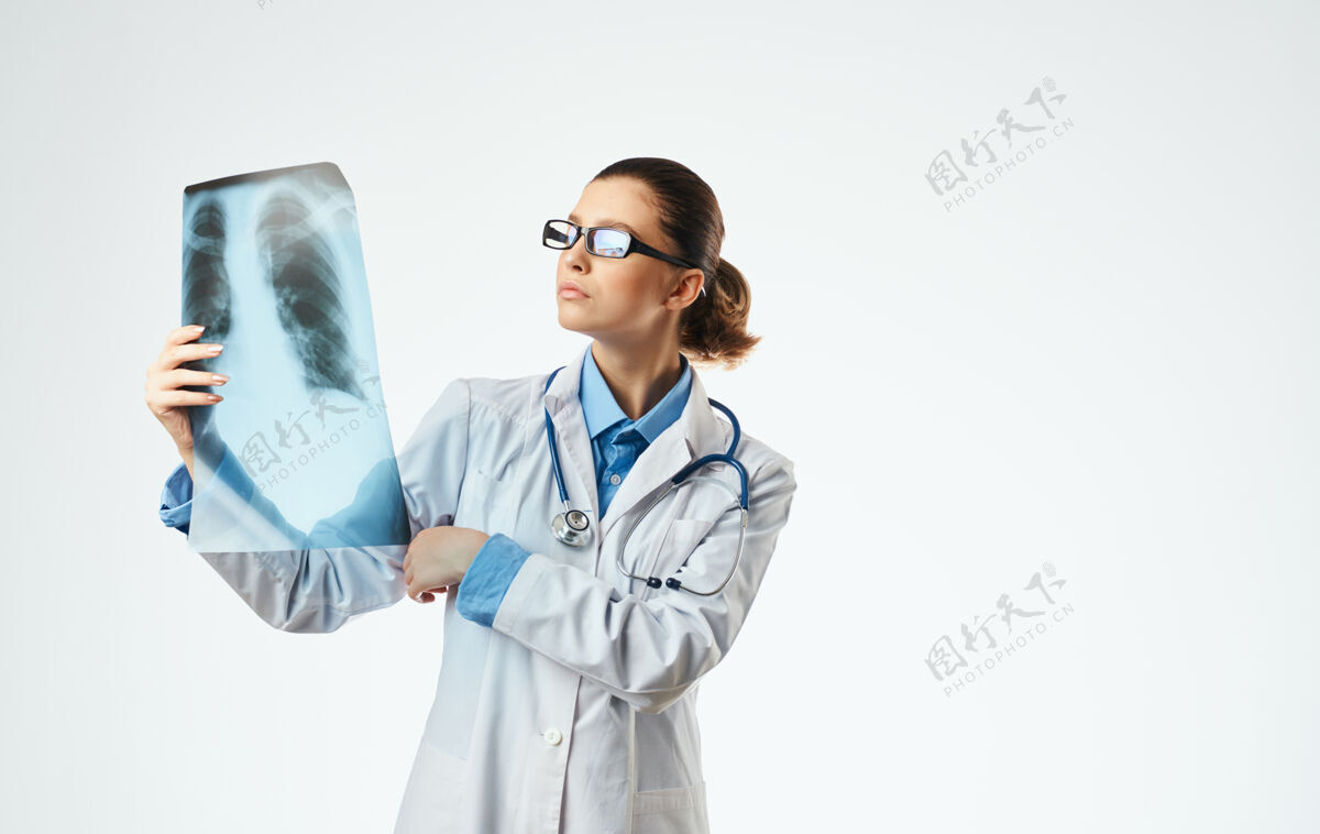 工作女医生用听诊器检查x光片和医用眼镜扫描医疗保健诊所