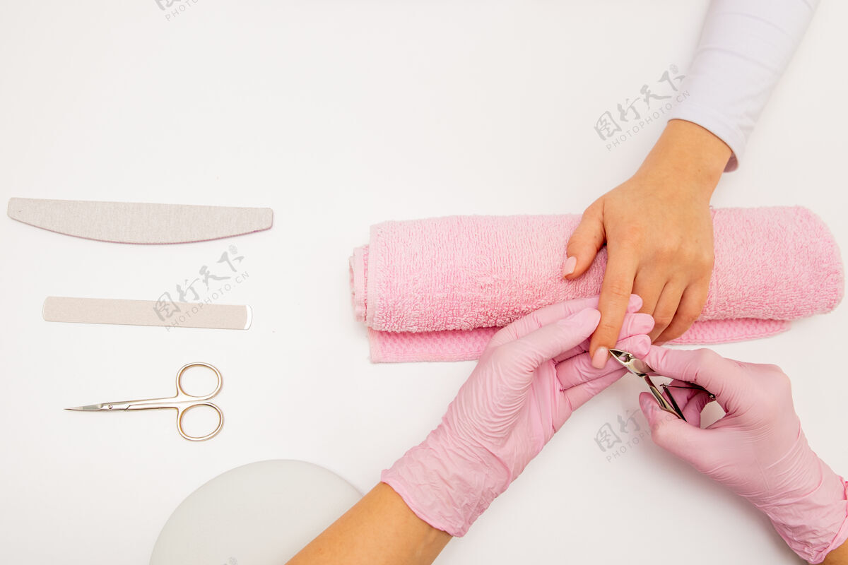 工具一个美甲师用指甲剪给她在美容院的客户修指甲的俯视图沙龙大师美甲的用指甲钳去角质甲专业删除自然