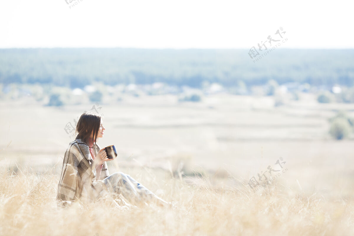 特写休息的年轻女子自然女性在草地上喝热茶舒适饮用放松
