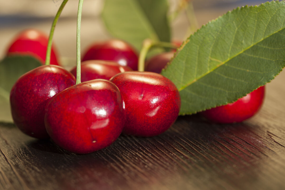 饮食红熟樱桃放在木桌上 绿叶放在桌上特写零食植物多汁