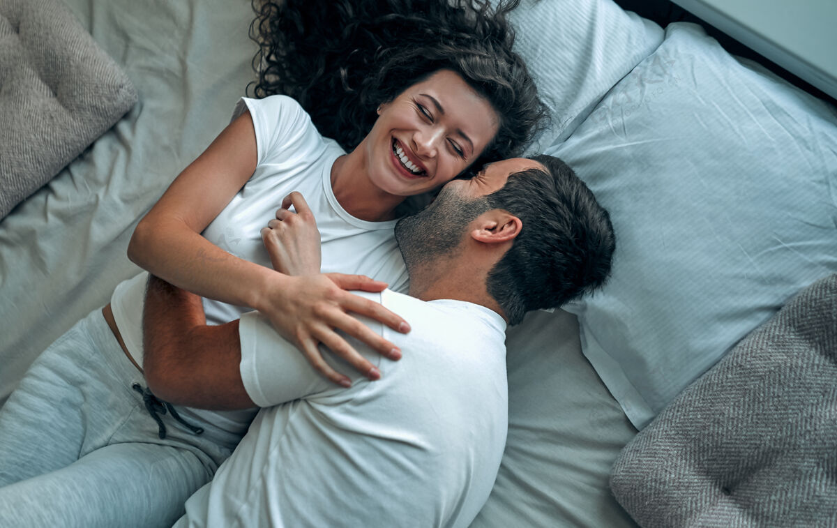 夫妻美丽的情侣在床上接吻性团结爱
