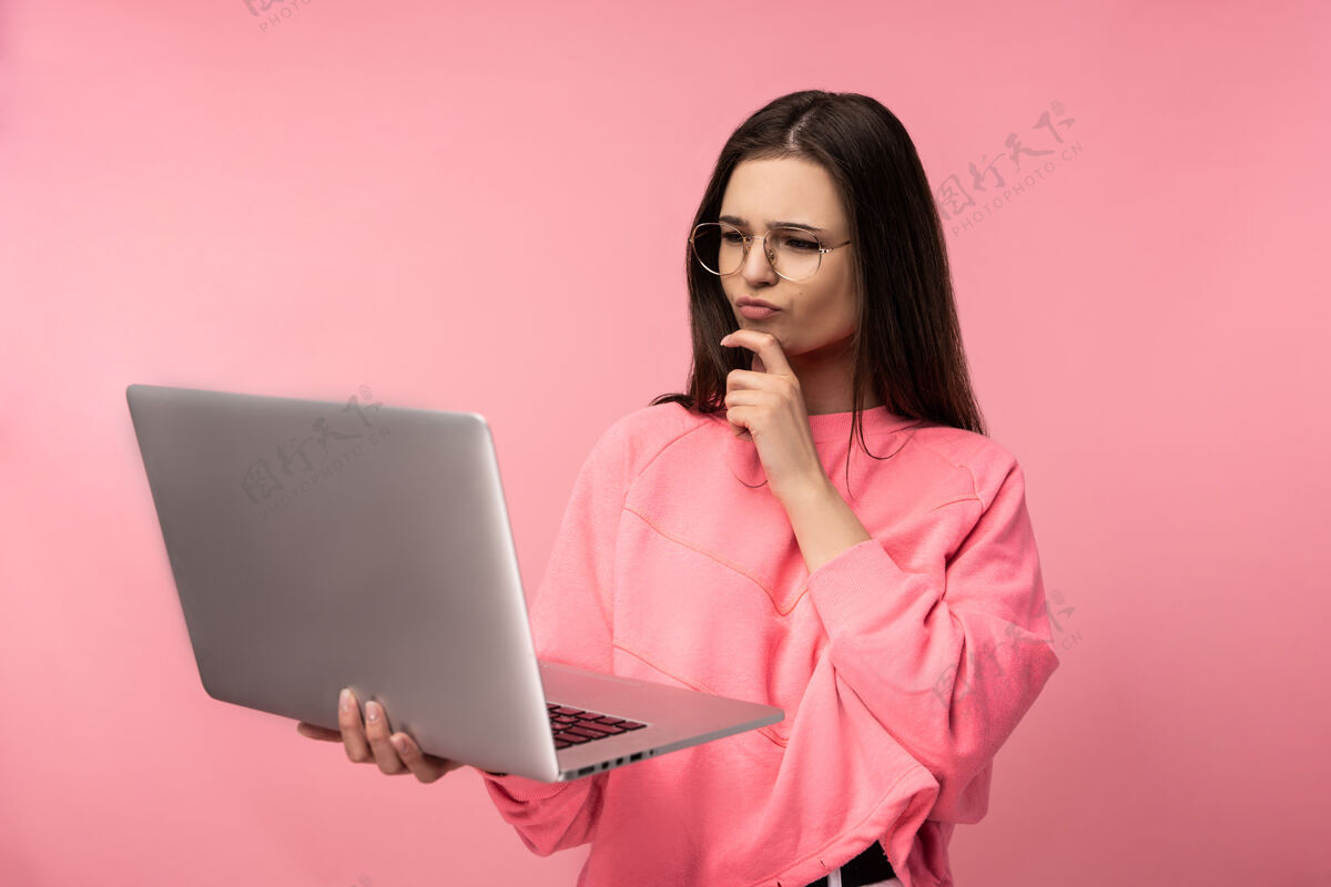 肖像照片中的美女对眼镜感兴趣并正在做决定 手持笔记本电脑上网工作表情享受头发