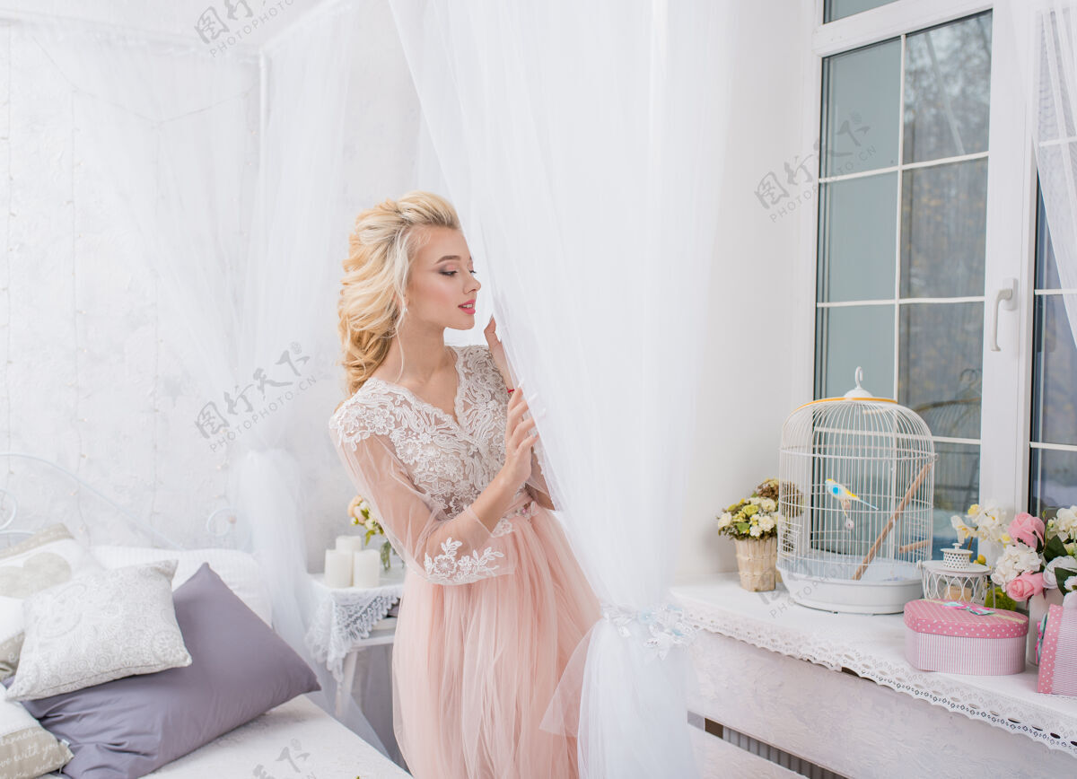 礼服年轻漂亮的时尚新娘手拿花束躺在床上装饰女孩成人优雅