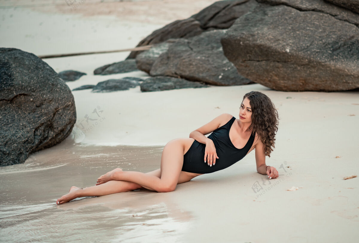 模特优雅的女人 留着长长的头发 穿着黑色豪华比基尼 在沙滩上放松海滩夏天假期姿势热带年轻人