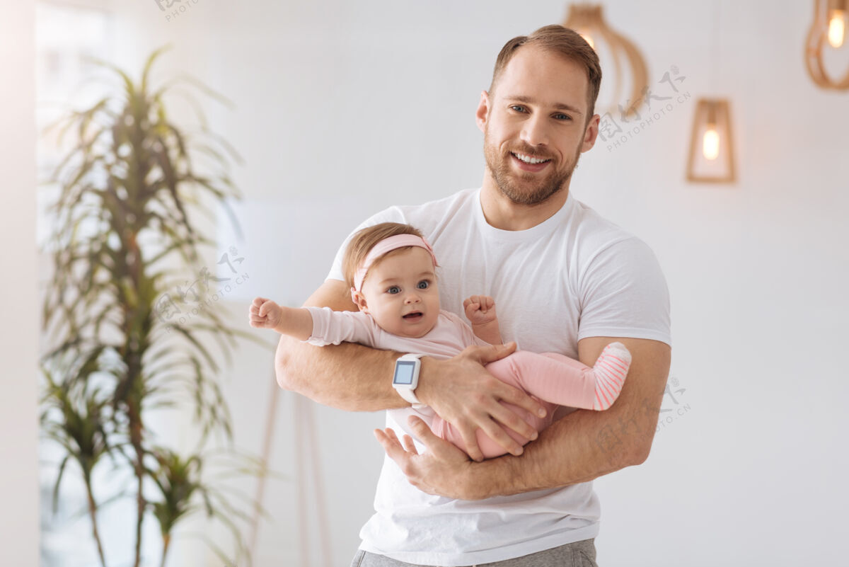 传统快乐时光一起运动可爱快乐的爸爸站在家里 抱着宝宝 同时表达积极的情绪女儿高兴无线