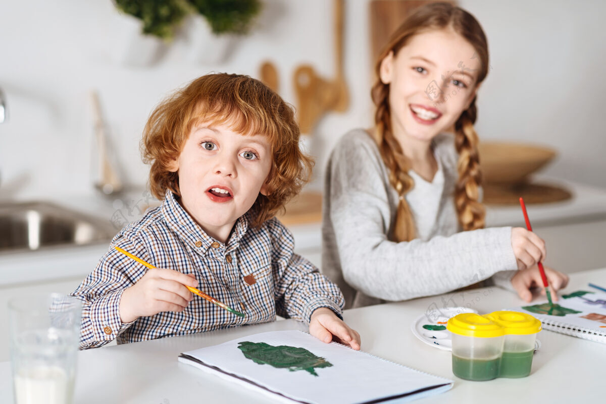 家庭作业树木和布什热情创意可爱的孩子们坐在厨房的桌子旁 享受着绘画的乐趣和过程而世代水彩画