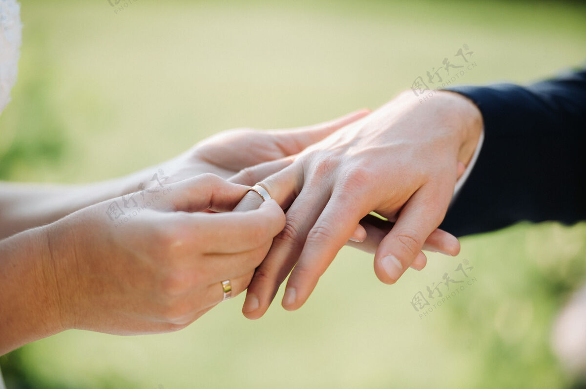 结婚戒指在婚礼那天 新娘把订婚戒指戴在新郎的手指上戒指男人珠宝