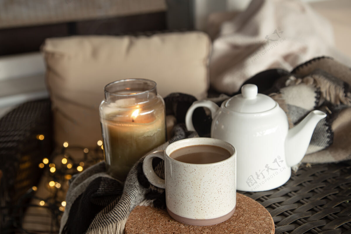静物一杯咖啡 一个水壶和一个燃烧着的杯子 构成了一个温馨的家庭蜡烛.家舒适理念咖啡细节蜡烛