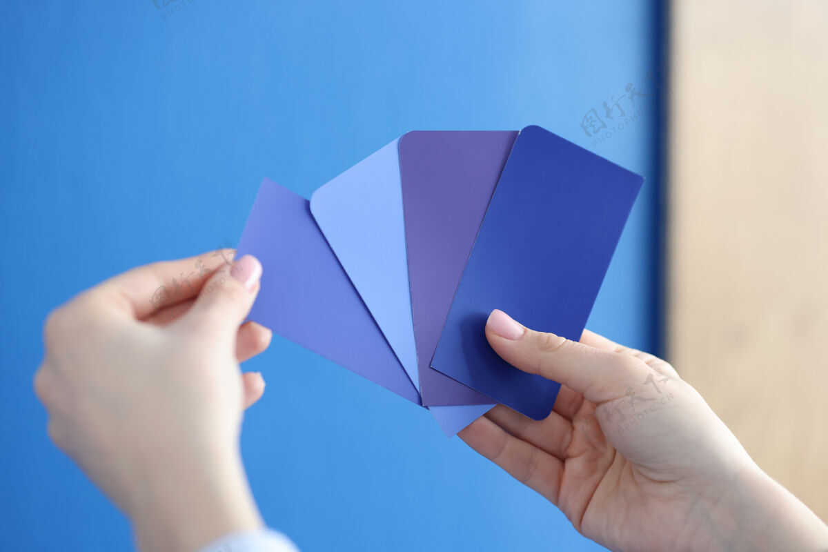 布局在手中的调色板与蓝色阴影对蓝色的墙壁色调维修趋势