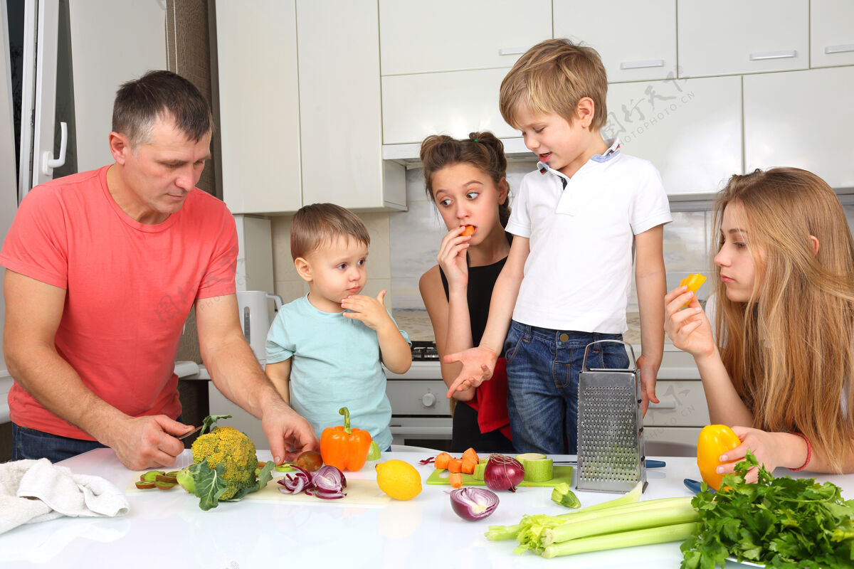 家庭一家人带着孩子切菜做饭女儿烹饪晚餐
