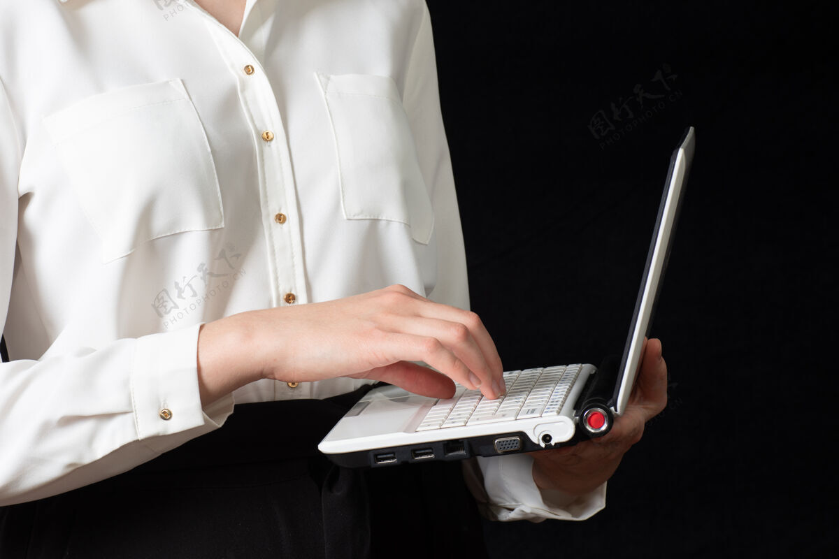 手指一只使用笔记本电脑触摸屏幕的女性手的特写镜头 被隔离在黑色背景上人员屏幕工作
