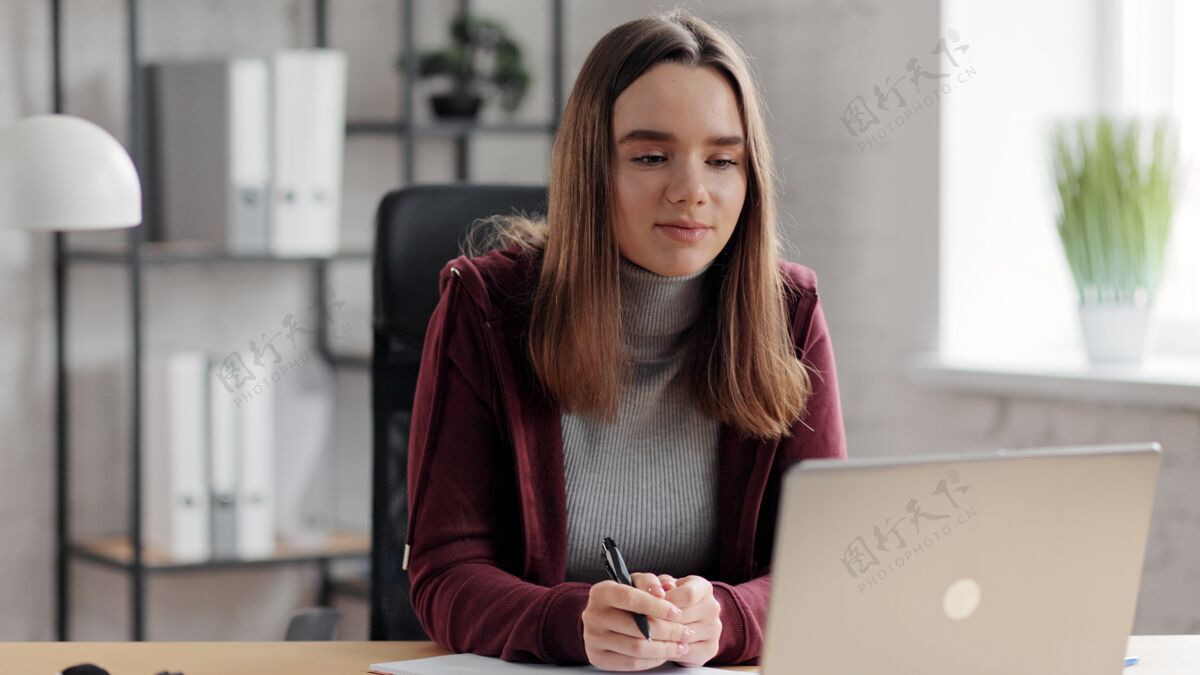 室内漂亮的年轻女孩在网上学习笔记本电脑.在线教育 远程工作 家庭教育笔记本在线学习专业
